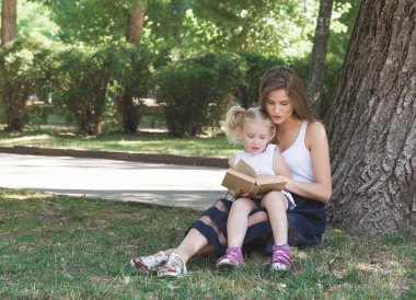 Anne ve kızı kitap okuyor.