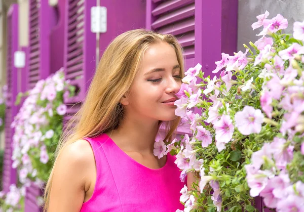 Mladá žena poblíž květiny — Stock fotografie