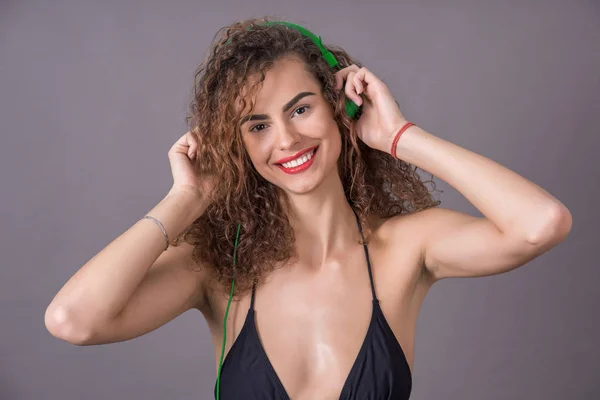 Mädchen im Bikini hört Musik über Kopfhörer — Stockfoto