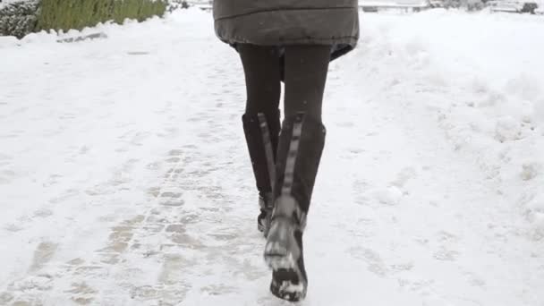 Piernas femeninas en botas sobre nieve — Vídeo de stock