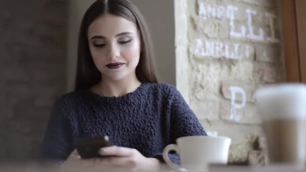 Женщина со смартфоном в кафе — стоковое видео