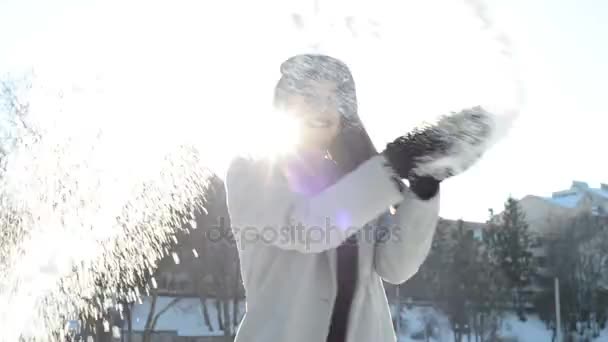 Молодая красивая женщина, играющая со снегом — стоковое видео