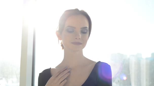 Vacker ung kvinna genom fönster — Stockvideo