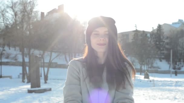 Молодая красивая женщина, играющая со снегом — стоковое видео