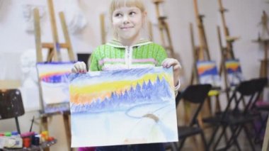 Küçük kız bir resmi gösterir 