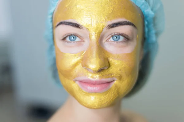 woman with gold facial mask