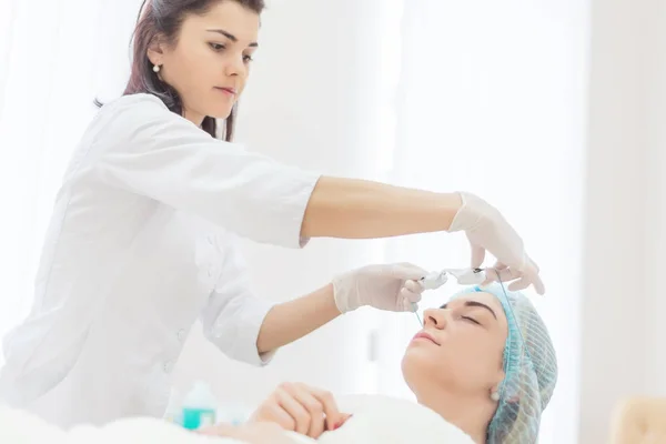 Beautician puts Protective glasses on patient — Stock Photo, Image