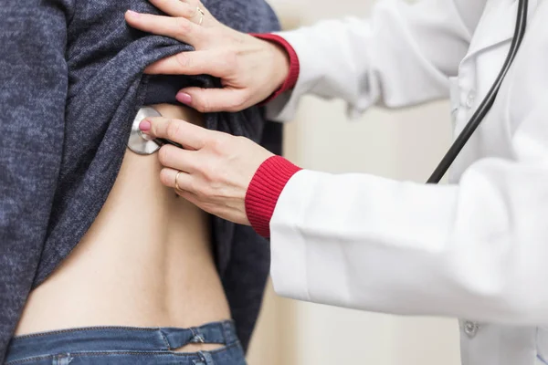 Médico examina chica con estetoscopio —  Fotos de Stock