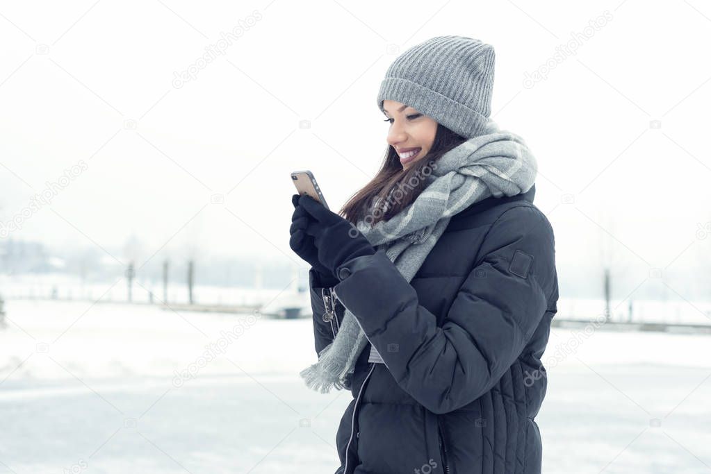 Girl with a mobile phone in winter