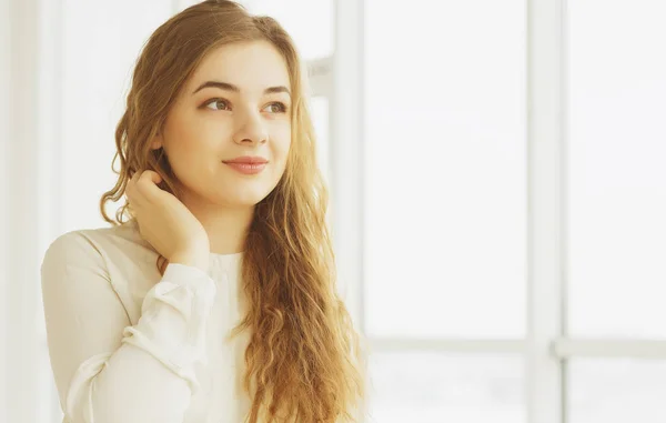 beautiful young woman by window