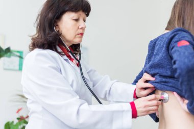 Doktor kız stetoskop ile inceliyor.