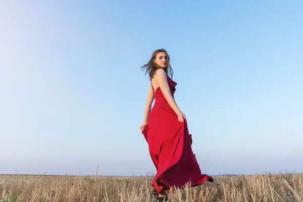 Kvinna i röd klänning i fältet — Stockfoto