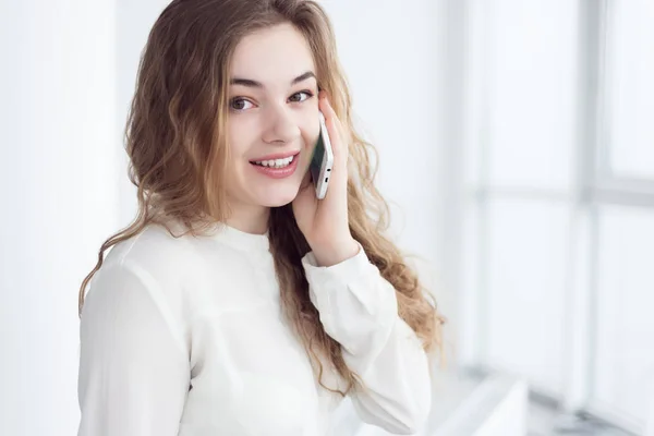 Mujer con teléfono por ventana — Foto de Stock