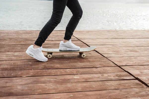 Skateboardista skateboarding na pozadí zamrzlého jezera. COP — Stock fotografie