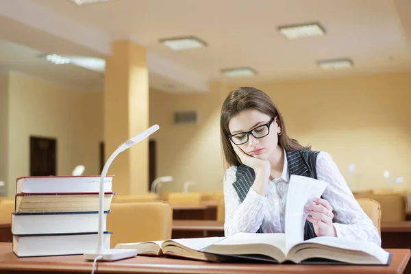 Gelangweilte junge Studentin liest ein Buch — Stockfoto