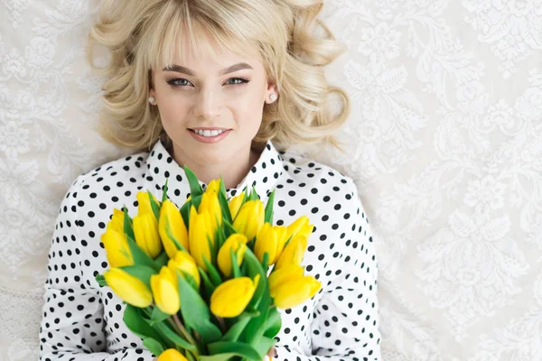 Happy woman with yellow tulips