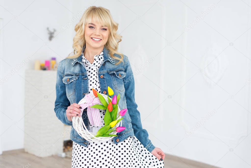 Happy young blonde Caucasian woman holding a wreath of flowers i