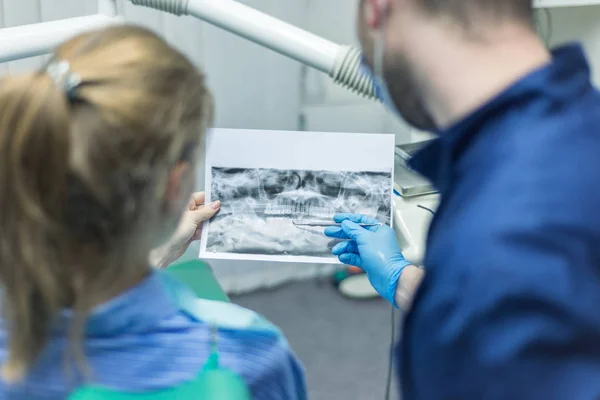 Doctor hablando con el paciente y enseñando una radiografía. Dentista c — Foto de Stock