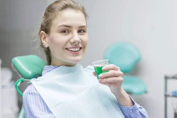 Paciente mujer enjuagando la boca con dentista en el fondo en clini — Foto de Stock