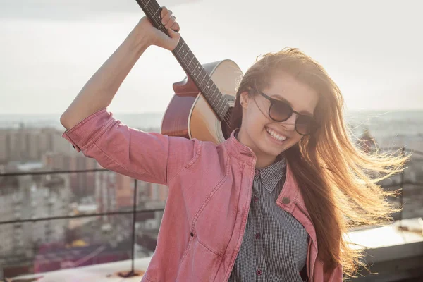 Jeune belle femme avec une guitare sur le toit — Photo