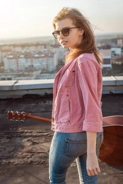 Jeune belle femme avec une guitare sur le toit — Photo