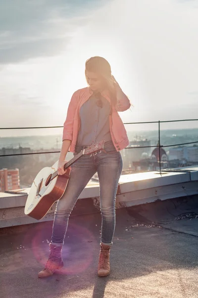 Młoda piękna kobieta z gitarą na dachu — Zdjęcie stockowe