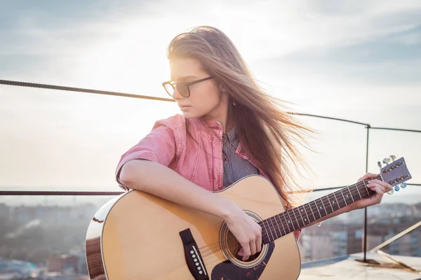 Jeune belle femme jouer à la guitare sur le toit gros plan — Photo