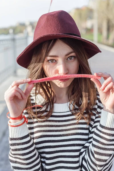 Mädchen mit langen rosa Kauzuckerbonbons — Stockfoto