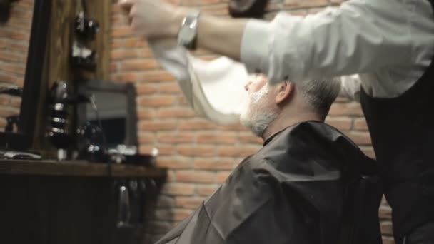 सक्रिय सेवानिवृत्त बुजुर्ग पुराने दाढ़ी वाले वरिष्ठ आदमी बालों वाली दुकान हेयरस्टाइलिस्ट में ग्रे बालों के साथ — स्टॉक वीडियो