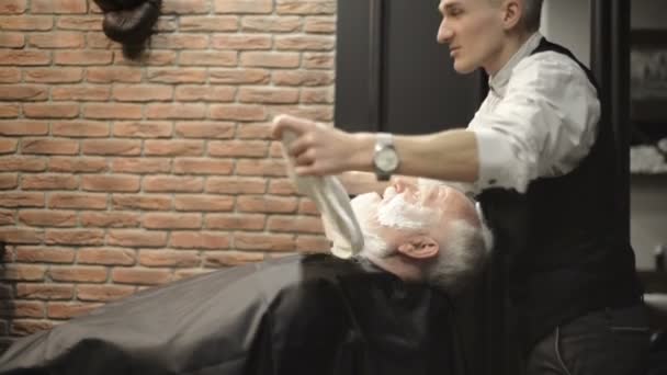 Actieve gepensioneerde ouderen oude bebaarde senior man leeftijd met grijzende haren in kapper winkel haarstylist — Stockvideo