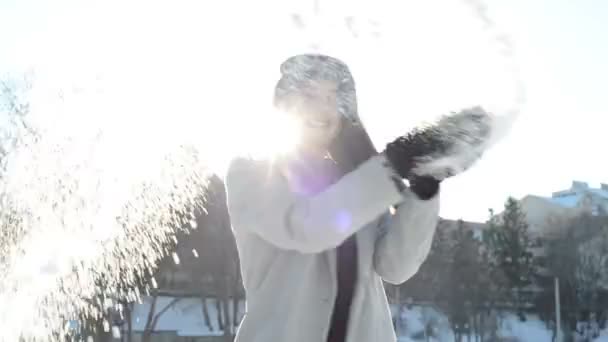 Młoda kobieta wyrzuca śnieg na zewnątrz — Wideo stockowe