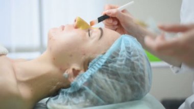 Yüz, kozmetik tedavi spa adlı sahip kadın altın yüz maskesi uygulamak güzellik uzmanı. Erkek güzellik salonunda üzerinde profesyonel güzellik uzmanı. Cilt prosedürler kozmetik temizlik.