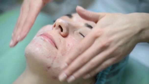 美容師クリーム スパで美容治療を有する顔とマッサージの女性に。プロの美容師が美容室で女性のマスクを適用します。クリーニング美容肌の顔の手順. — ストック動画