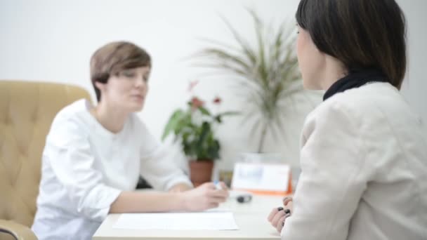 Female doctor consulting talking give information to patient results in exam room. medicine, health care and people concept — Stock Video