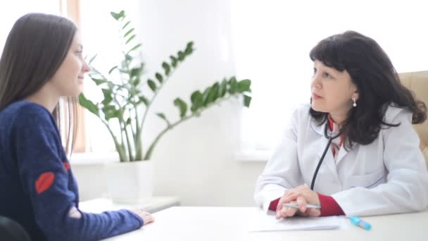 Női orvos tanácsadás beteg beszélő ad információt eredményez vizsga szoba. orvosi, egészségügyi ellátás és emberek koncepció — Stock videók