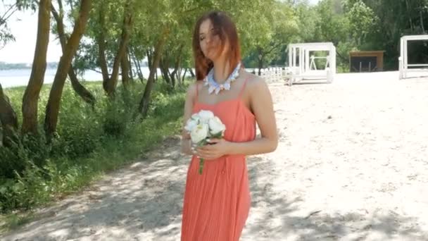 Giovane bella donna che tiene un bouquet con fiori bianchi — Video Stock