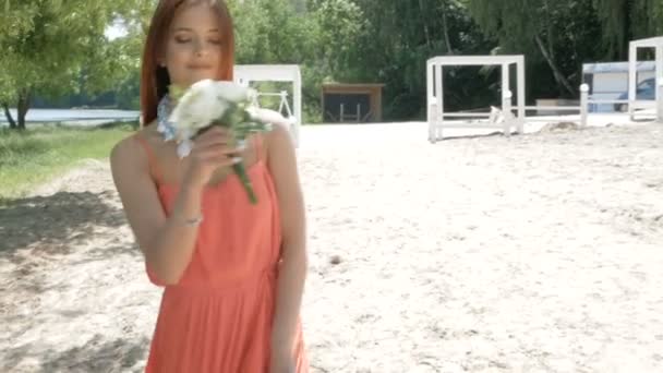 Молода красива жінка тримає букет з білими квітами — стокове відео
