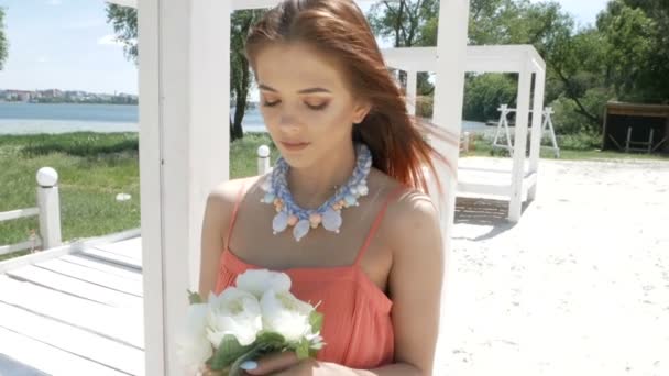 Joven hermosa mujer sosteniendo un ramo con flores blancas — Vídeo de stock