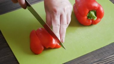 Gıda hazırlama Şef kesme biber. Eller closeup ahşap masa sebze yemek
