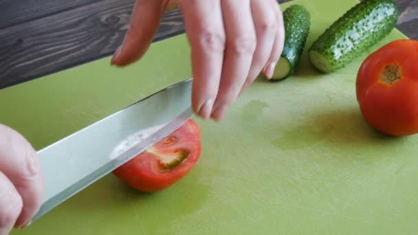 Főzés és home concept - zár-megjelöl-ból női kézi vágás paradicsom vágódeszka éles késsel — Stock videók