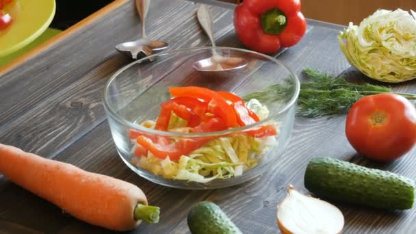 Домохозяйка смешивает овощной салат — стоковое видео