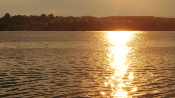 Moře, slunce pozadí jezero. Červená, oranžová barevná voda, obloha červená. Slunce zapadá odlesk oblohy. — Stock video