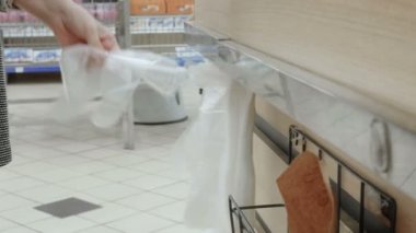 Tek kullanımlık eldiven koyarak giymek. Taze ekmek fırın ürünleri süpermarkette satın alma kadın