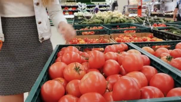 Γυναίκα σε ένα σούπερ μάρκετ επιλέγει τις ντομάτες επιλογή λαχανικών σε σούπερ μάρκετ. — Αρχείο Βίντεο