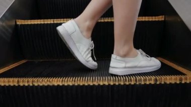 kadın kişi Modern kentsel iç yürüyen merdiven, bacaklar Stepping hareketli merdiven kolay fırsat veya başarı kavramı olarak kamera üzerinden.