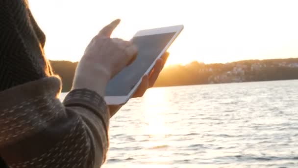Закрыть руку женщины с помощью планшетного компьютера сенсорный экран наружный закат — стоковое видео