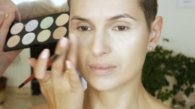 Sarışın bir kadın sanatçı yapar makyaj uzmanı model güzel yumuşak makyaj daha önce önemli bir olay. adım adım