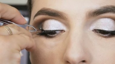 Sarışın bir kadın sanatçı yapar makyaj uzmanı model güzel yumuşak makyaj daha önce önemli bir olay. sahte kirpik. adım adım.
