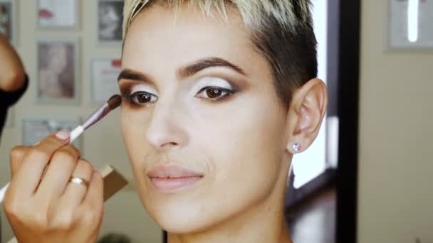 Makeup Specialist artist gör en blond kvinna modell vacker mild makeup eye innan en viktig händelse. steg för steg — Stockvideo