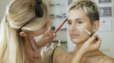 Sarışın bir kadın sanatçı yapar makyaj uzmanı model güzel yumuşak makyaj daha önce önemli bir olay. adım adım